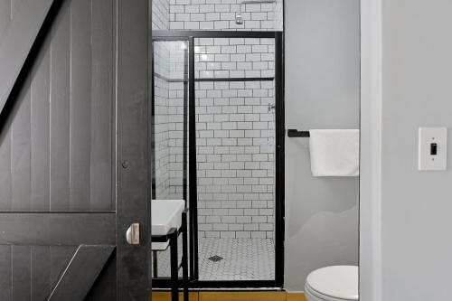 a bathroom with a toilet and a glass shower door at The Heriot City Centre Apartments in Cape Town