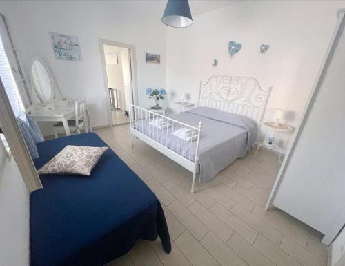 - une chambre blanche avec un lit et une chaise dans l'établissement Borgata Mazzarelli 2, à Marina di Ragusa