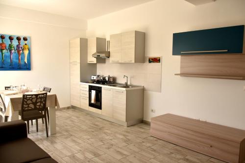 a kitchen with white cabinets and a table with a dining room at BoaOp Apartaments in Sal Rei