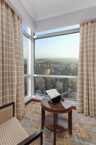 a room with a laptop on a table in front of a large window at Swissotel Al Maqam Makkah in Makkah
