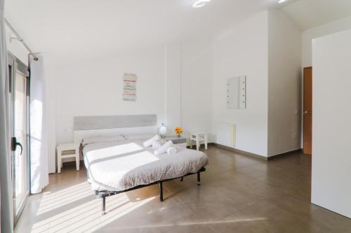 1 dormitorio blanco con 1 cama en una habitación en Ca Baells, en Sant Jordi de Cercs
