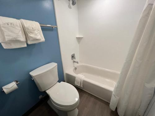 a bathroom with a white toilet and a bath tub at Fenwick Inn in Ocean City
