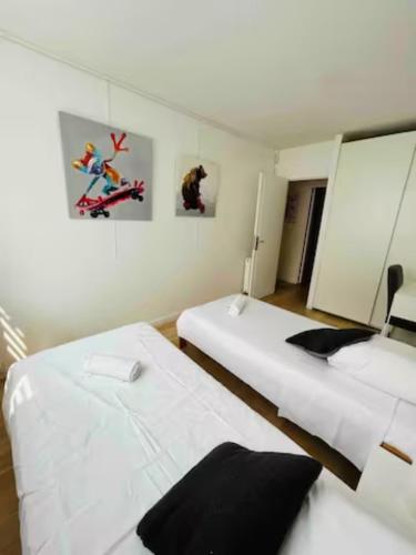 two beds in a room with white walls at Chambre double dans appartement, fibre, RER B in Antony