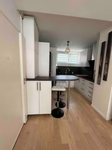 a kitchen with white cabinets and a table in it at Chambre double dans appartement, fibre, RER B in Antony