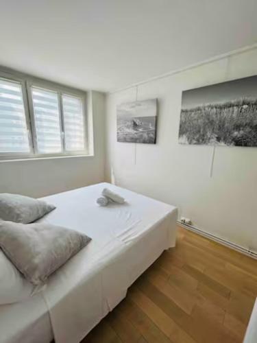 a white bedroom with a large bed and two windows at Chambre double dans appartement, fibre, RER B in Antony