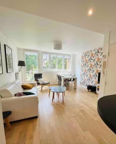 a living room with a white couch and a table at Chambre double dans appartement, fibre, RER B in Antony