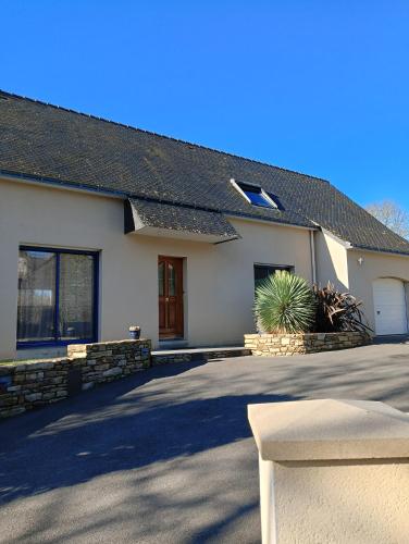 une maison blanche avec une allée et une plante dans l'établissement Maison au calme et proche de la mer, à Arzal