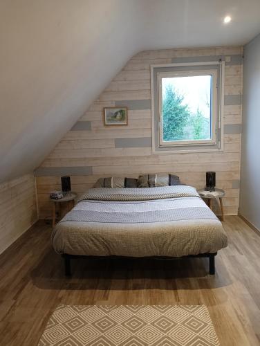 Schlafzimmer mit einem Bett und einem Fenster in der Unterkunft Maison au calme et proche de la mer in Arzal