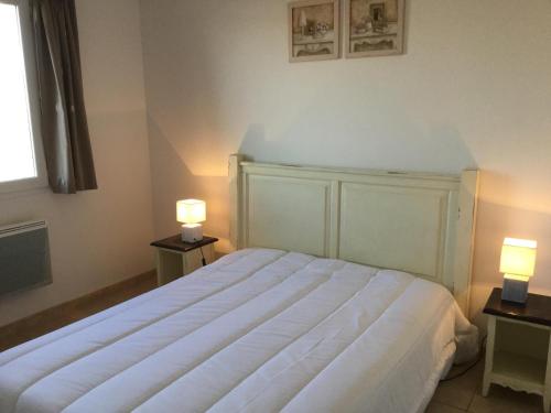 ein Schlafzimmer mit einem großen weißen Bett mit zwei Lampen in der Unterkunft Charming rental with shared-pool in the Alpilles. in Mouriès