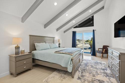 een slaapkamer met een bed, een dressoir en een raam bij Harbor Living in Oxnard