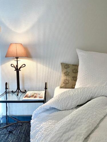 a bedroom with a bed and a table with a lamp at Grand Hôtel De La Poste in Salon-de-Provence