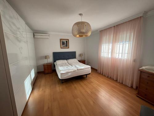 1 dormitorio con 1 cama y luz colgante en Gran villa en Torremolinos, en Torremolinos