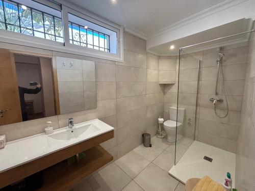 トレモリノスにあるGran villa en Torremolinosのバスルーム(洗面台、ガラス張りのシャワー付)