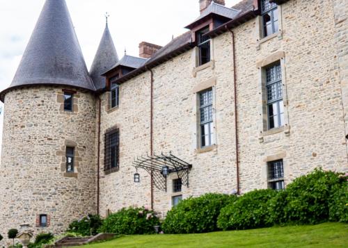 ein altes Schloss mit Türmen auf einem grünen Rasen in der Unterkunft Château du Bertry in La Bouexière