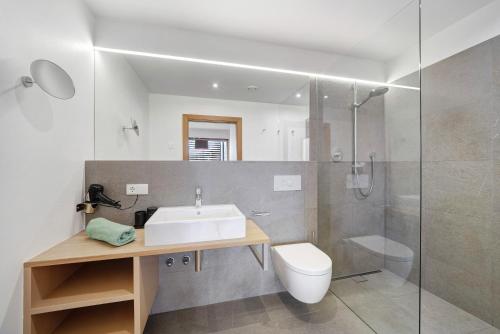 een badkamer met een wastafel, een douche en een toilet bij Panoramasuite - Dahoam in Schenna