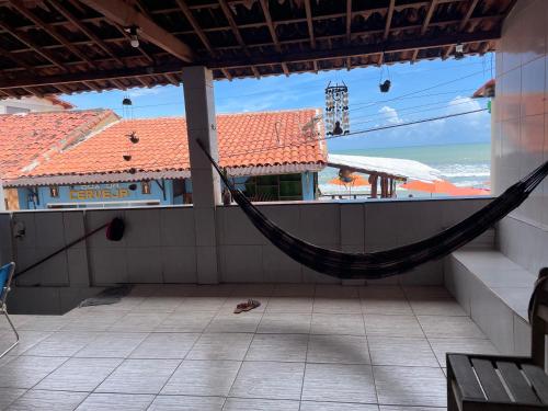 a hammock on a balcony with a view of the ocean at Casa em Baia Formosa-RN in Baía Formosa