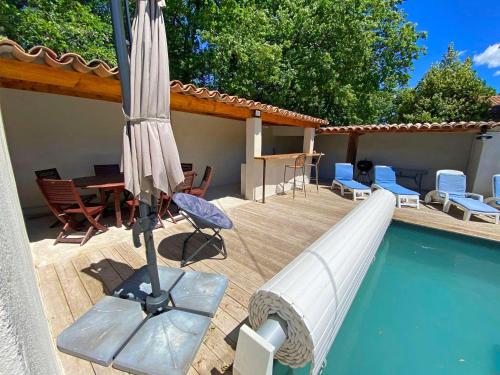 MaubecにあるNice house with private-pool situated in the heart of the Luberonのスイミングプールのそばのパラソルと椅子