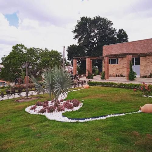um jardim em frente a um edifício de tijolos em pousada e balneário parque das aguas em Umari
