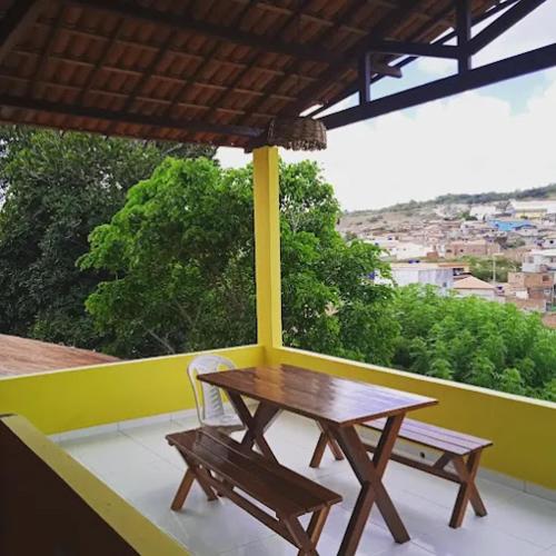 een houten tafel en een bank op een balkon bij pousada e balneário parque das aguas in Umari