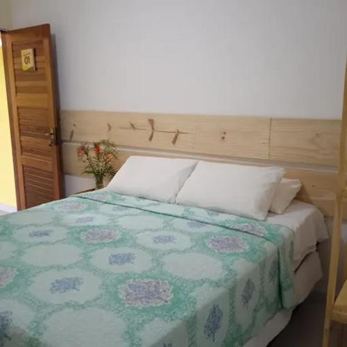 um quarto com uma cama com uma colcha verde e branca em pousada e balneário parque das aguas em Umari