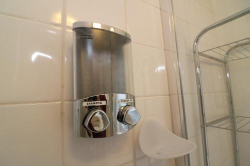 a trash can in the corner of a shower at Signature - Atholl House Glasgow Airport in Paisley