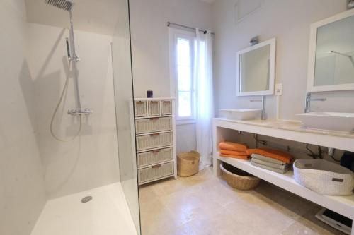 een witte badkamer met een douche en een wastafel bij superb prestigious mas with pool in the countryside of caumont sur durance, close to avignon, sleeps 8 in Caumont-sur-Durance