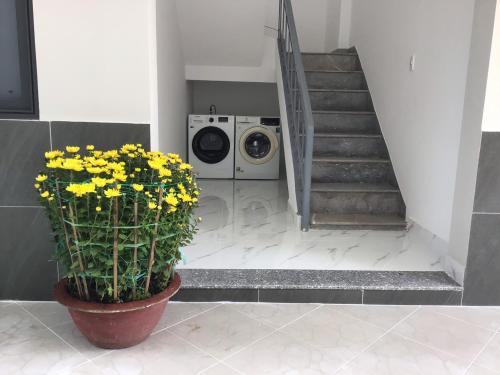 a laundry room with a washing machine and yellow flowers at Koala1 Apartment in Vung Tau