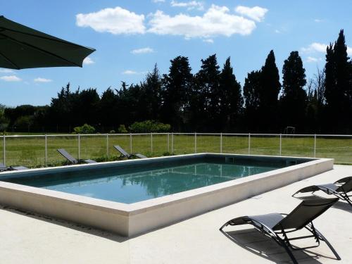 フォンヴィエイユにあるair-conditioned family house with fenced pool in fontvieille in the alpilles, sleeps 8のスイミングプール(椅子、パラソル付)
