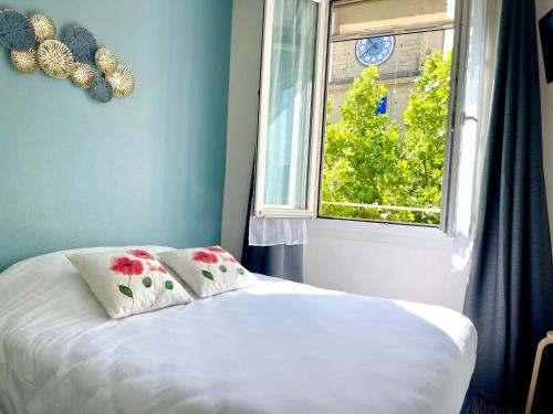 a bed in a room with a window at Grand Hôtel De La Poste in Salon-de-Provence