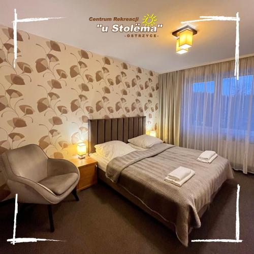a bedroom with a bed and a chair at Centrum Rekreacji U Stolema in Ostrzyce