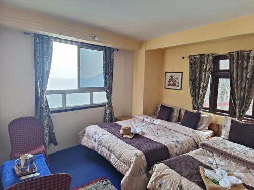 sypialnia z 2 łóżkami i oknem w obiekcie GRG Mountview By Darjeeling w mieście Dardżyling