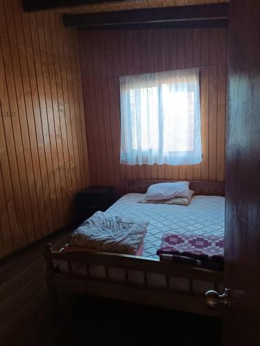- une petite chambre avec un lit et une fenêtre dans l'établissement Don Agustín, à Lago Ranco