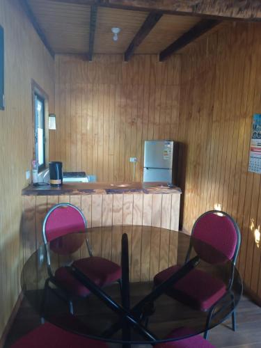 2 chaises et une table en verre dans une pièce dans l'établissement Don Agustín, à Lago Ranco