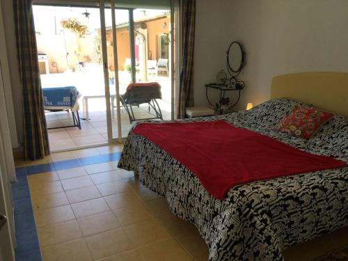 a bedroom with a bed and a view of a patio at beautiful vacation home with pool located in robion with a pretty view on the luberon. 8 people. in Robion en Luberon