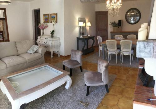 - un salon avec un canapé, une table et des chaises dans l'établissement authentic provencal mas with pool, in the countryside of the village of sénas, close to the luberon and the alpilles, sleeps 8., à Sénas