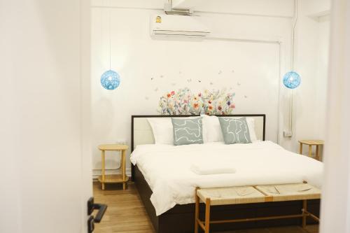 een slaapkamer met een wit bed en een bank ernaast bij 2BR Stylist Rare Find China Town in Bangkok