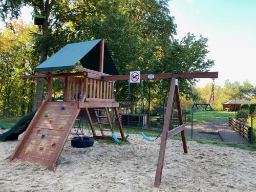 a wooden playground with a slide in the sand at Centrum Rekreacji U Stolema in Ostrzyce