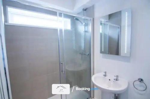 uma casa de banho com um chuveiro e um lavatório. em Charming 1 Bedroom Flat By J F SUITES Short Lets & Serviced Accommodation with WiFi em Kent