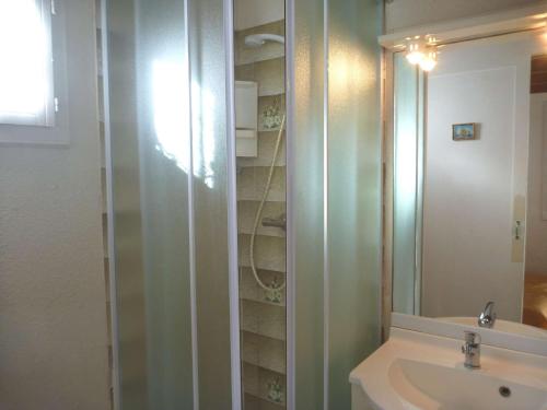 une salle de bain avec un lavabo et une douche en verre dans l'établissement Charmante maison proche plage avec parking privé et terrasse - FR-1-387-84, à Marseillan