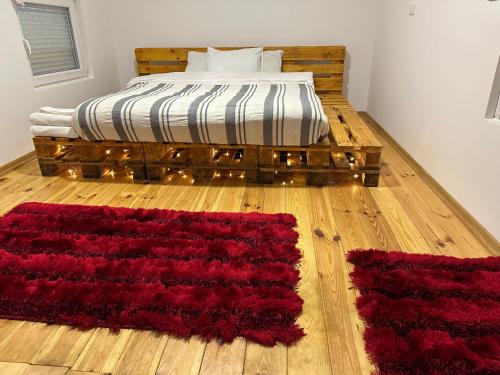 1 dormitorio con 1 cama con alfombras rojas en el suelo en Apartman2, en Podgorica