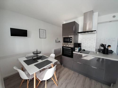 une cuisine avec une table et des chaises dans une cuisine dans l'établissement Charmant studio moderne proche plage avec parking privatif à Saint-Hilaire-de-Riez - FR-1-324A-28, à Saint-Hilaire-de-Riez