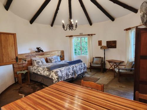 een slaapkamer met een bed en een tafel bij Softwaters Farm Guesthouse in Louis Trichardt