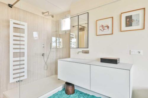 ein weißes Bad mit einer Dusche und einem Waschbecken in der Unterkunft Bright functional flat with balcony- view Panthéon in Paris