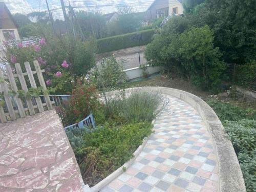 a garden with a path and flowers and a fence at Le Gîte des Alleux in Saint-Julien