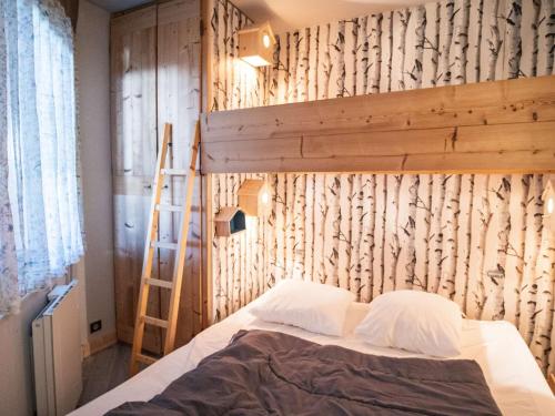 - une chambre avec des lits superposés et un mur en bois dans l'établissement Val Thorens : Appartement 4 pers rénové avec balcon, local à ski, au pied des pistes - FR-1-637-70, à Val Thorens