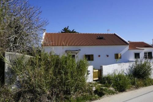 a white house with a red roof at Casa Bonabal- 15 min from Ericeira 