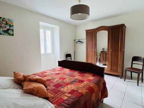 um quarto com uma cama, uma cadeira e um espelho em Maison Louhossoa, 4 pièces, 6 personnes - FR-1-495-134 em Louhossoa