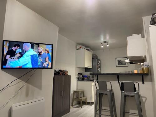 uma sala de estar com uma televisão de ecrã plano na parede em Studio 25m² Proche Tour Eiffel em Paris