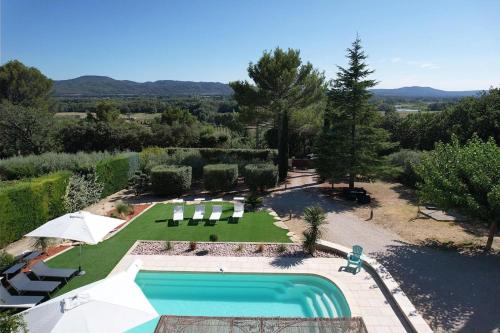 very beautiful villa with private pool in the luberon enjoying a magnificent view of the durance valley, located in puget – 10 people. في Puget: اطلالة علوية على مسبح في حديقة