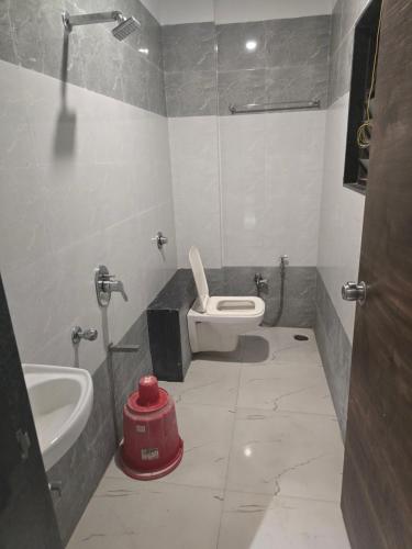 ein Badezimmer mit einem weißen WC und einem Waschbecken in der Unterkunft HOTEL RAMJI in Karmād
